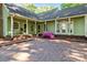 Covered porch with wood-slat swing leads to a large brick patio and a manicured yard at 101 Blueberry Hill Dr, Statesville, NC 28625