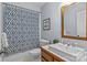 Bathroom with blue patterned shower curtain, wooden mirror, and a white vanity at 101 Blueberry Hill Dr, Statesville, NC 28625