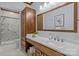 Bathroom featuring a large mirror, spacious vanity, and walk-in shower with marble-look tile at 101 Blueberry Hill Dr, Statesville, NC 28625