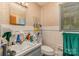 Compact bathroom with patterned wallpaper, tiled walls, and ample counter space, offering functionality and character at 102 Forest Ct, Huntersville, NC 28078