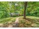 View of a brick home surrounded by mature trees and greenery, showcasing the property's peaceful setting at 102 Forest Ct, Huntersville, NC 28078