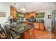 Eat-in kitchen featuring stainless steel appliances, wood cabinets, granite counters, and hardwood flooring at 102 Forest Ct, Huntersville, NC 28078