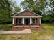 Charming brick home featuring a cozy front porch with classic white columns and inviting curb appeal at 119 Washington St, York, SC 29745
