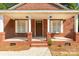 Charming brick home featuring a welcoming front porch with white columns and a stylish front door at 119 Washington St, York, SC 29745