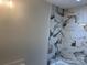 Bathroom features white marble-look tile in the shower and tub area at 122 39Th Avenue Nw Ct, Hickory, NC 28601
