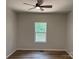 Neutral bedroom with ceiling fan, window, and modern vinyl flooring at 122 39Th Avenue Nw Ct, Hickory, NC 28601