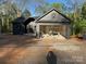 Modern black home exterior featuring an open garage and wooded surroundings at 122 39Th Avenue Nw Ct, Hickory, NC 28601