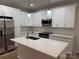 Bright kitchen featuring white cabinets, stainless steel appliances, and a center island with a white countertop at 122 39Th Avenue Nw Ct, Hickory, NC 28601