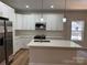 Kitchen with white cabinets, stainless steel appliances, a center island, and modern pendant lights at 122 39Th Avenue Nw Ct, Hickory, NC 28601