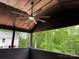 Relaxing covered porch with wooden ceiling, modern fan, and view of the lush greenery at 122 39Th Avenue Nw Ct, Hickory, NC 28601