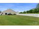 Spacious backyard featuring a well-manicured lawn and white picket fence, providing privacy and room to roam at 13012 Hunting Birds Ln, Charlotte, NC 28278