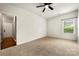 Spacious bedroom with a ceiling fan, carpeted floor, and bright window at 13012 Hunting Birds Ln, Charlotte, NC 28278