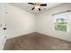 This carpeted bedroom has a fan and a window, offering ample natural light at 13012 Hunting Birds Ln, Charlotte, NC 28278