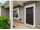 Close-up of the front door with decorative trim, a window, and manicured landscaping at 13012 Hunting Birds Ln, Charlotte, NC 28278