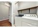 Functional laundry room includes updated washer and dryer with shelf at 13012 Hunting Birds Ln, Charlotte, NC 28278
