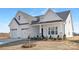 Stylish new home featuring an attached three-car garage, manicured landscaping, and a welcoming covered porch at 13097 Arnold Palmer Cir # 844, Lancaster, SC 29720