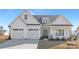 Charming two-story home with a three-car garage, stylish front door, and a well-manicured lawn at 13097 Arnold Palmer Cir # 844, Lancaster, SC 29720