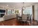 Open dining area with hardwood floors, modern light fixture, and view of the cozy living room at 13103 Union Square Dr, Huntersville, NC 28078