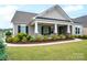 Charming home showcasing a welcoming front porch with stone-clad columns and lush landscaping at 13103 Union Square Dr, Huntersville, NC 28078