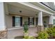 Inviting covered porch enhanced by stone columns, black shutters, and decorative potted plants at 13103 Union Square Dr, Huntersville, NC 28078