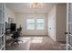 Bright home office featuring a large desk with multiple monitors and natural light from dual windows at 13103 Union Square Dr, Huntersville, NC 28078