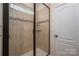 Tiled shower with glass door, decorative tile band, built-in shelf, and neutral color palette at 13103 Union Square Dr, Huntersville, NC 28078