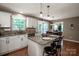 Well-lit kitchen with granite countertops, white cabinets, stainless steel appliances, and barstool seating at the island at 145 Meadow Pond Ln, Mooresville, NC 28117
