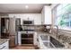 Modern kitchen featuring stainless steel appliances, white cabinets, granite countertops, and a window offering natural light at 145 Meadow Pond Ln, Mooresville, NC 28117