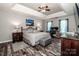 Spacious bedroom featuring a tray ceiling, dark wood floors, a ceiling fan and an attached office space at 145 Meadow Pond Ln, Mooresville, NC 28117