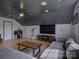 Bright living room featuring a modern gray sofa, dark ceiling, and a large TV at 1488 Meadow Glen Ln, Rock Hill, SC 29730