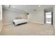 Bright bedroom featuring soft carpeting, tray ceilings, and ample space at 15312 Ravenall Dr, Huntersville, NC 28078