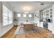 Bright dining room featuring a modern chandelier, beverage center, and ample natural light from large windows at 15312 Ravenall Dr, Huntersville, NC 28078