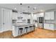 Modern kitchen with white cabinets, an island with seating, and stainless steel appliances at 15312 Ravenall Dr, Huntersville, NC 28078