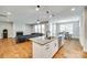 An open-concept kitchen flows into the living and dining areas, showcasing modern design and functionality at 15312 Ravenall Dr, Huntersville, NC 28078