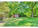 Spacious backyard showcasing a storage shed with a garage door and ample green space at 1540 Neely Store Rd, Rock Hill, SC 29730