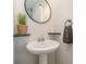 Pedestal sink in bathroom with modern fixtures, decorative mirror, and stylish accessories at 17231 Rider Wood Ln, Charlotte, NC 28278