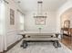 Stylish dining room featuring a long wooden table, bench seating, and elegant modern lighting at 17231 Rider Wood Ln, Charlotte, NC 28278