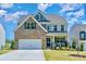 Charming two-story home with a well-manicured lawn, brick accents, a two-car garage and welcoming front porch at 17231 Rider Wood Ln, Charlotte, NC 28278