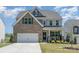 Charming two-story home with a brick and gray facade, well-maintained lawn, and a welcoming front porch at 17231 Rider Wood Ln, Charlotte, NC 28278