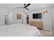 Bright bedroom with ceiling fan, flat screen tv, natural wood dresser, and cozy bed at 179 Bezelle Ave # 34, York, SC 29745