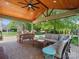 Relaxing covered patio with brick floor, wood ceiling, lounge seating, and backyard views at 2002 Potomac Rd, Indian Trail, NC 28079