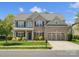 Charming two-story home with brick and siding, lush landscaping, and a three-car garage at 2002 Potomac Rd, Indian Trail, NC 28079