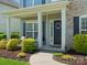 Welcoming covered porch with decorative wreath, stylish seating, and colorful flower beds at 2002 Potomac Rd, Indian Trail, NC 28079