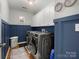 A tidy laundry room with modern machines and overhead storage at 2002 Potomac Rd, Indian Trail, NC 28079