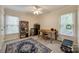 Bright bedroom with a ceiling fan, two windows, desk, bookshelf, and a decorative area rug at 2199 Lookout Pt, Rock Hill, SC 29732