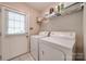 Well-lit laundry room featuring a washer, dryer, shelving, and exterior door to the backyard at 2199 Lookout Pt, Rock Hill, SC 29732