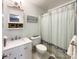 Cozy bathroom with a white vanity, a decorative mirror, a shower and tub combo, and a colorful shower curtain at 2214 Cannonade Ct, Matthews, NC 28105