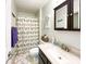 Well-lit bathroom with a granite countertop vanity, decorative mirror, and charming shower curtain at 2214 Cannonade Ct, Matthews, NC 28105