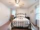Bright bedroom with neutral walls, an iron bed frame, a ceiling fan, and two windows allowing in natural light at 2214 Cannonade Ct, Matthews, NC 28105