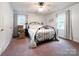 Bright bedroom with an iron bed frame, neutral walls, and two windows offering plenty of natural light at 2214 Cannonade Ct, Matthews, NC 28105